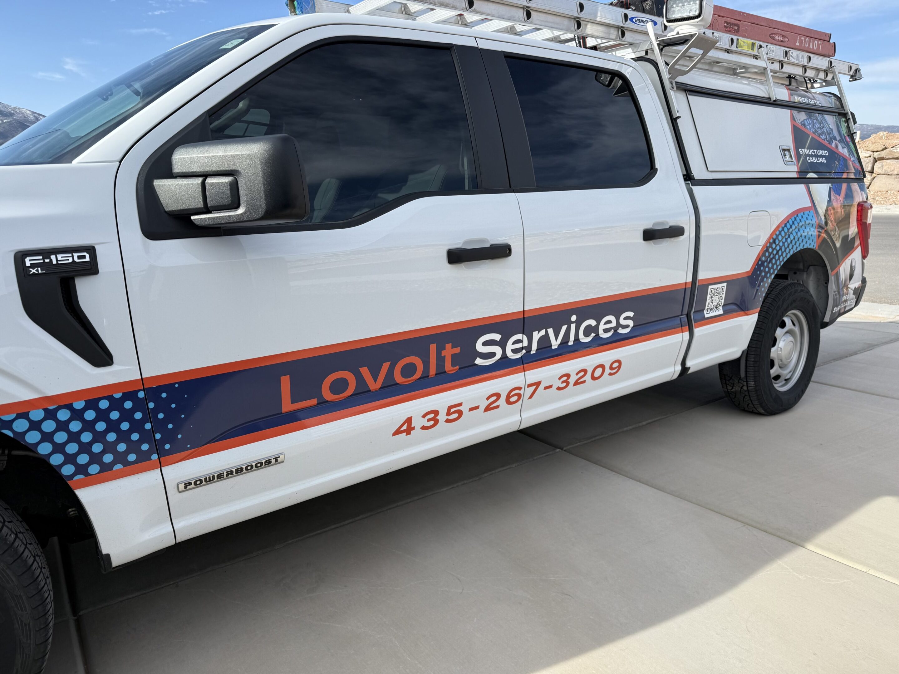 Service truck with company branding and ladder.